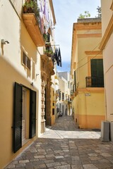 A narrow street between the old houses of Gallipoli, an old village in the province of Lecce in Italy.