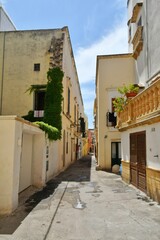 A narrow street between the old houses of Gallipoli, an old village in the province of Lecce in...