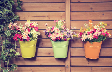 Fototapeta na wymiar colorful artificial plastic flower in flower Pots Hanging with fence