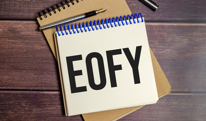notebook with the word End of Financial Year on wooden background