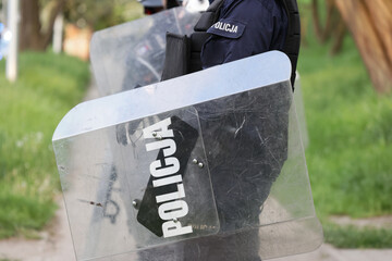 Polska Policja dyżurna, policjant prewencyjny z tarczą. © FotoDax