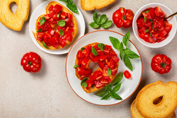 Bread, basil and tomato. Friselle or frese, a type of twice-baked bagel shaped bread from Puglia,...