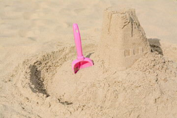 Fototapeta na wymiar Beautiful sand castle and plastic toy on beach