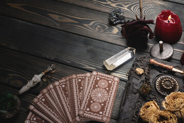 Tarot cards and magic book on the old wooden table background top view.