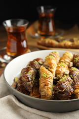 Delicious sweet baklava in bowl on table, closeup