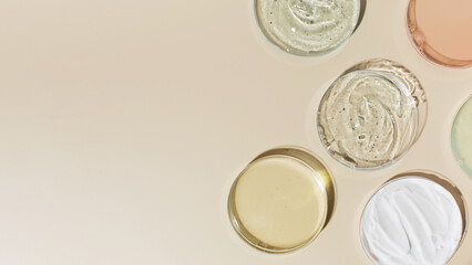 Various cosmetic products in Petri dishes on beige background view from above. Copy space