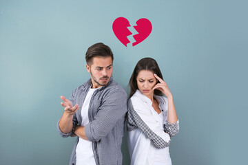 Upset young couple and illustration of broken heart on color background. Relationship problems