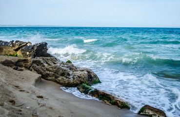 Fototapeta na wymiar Turquoise shallow water surface and rocks stones on sea floor.