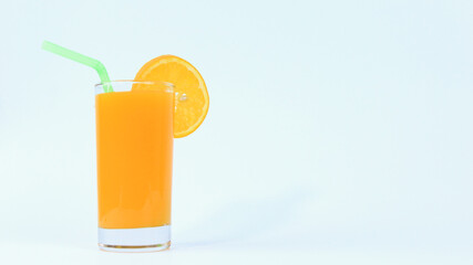 A glass of orange juice with fresh piece of sliced fruit and pipe in it on white background