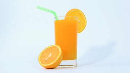 a Glass of orange juice with orange sliced in half isolated on white background with green pipe