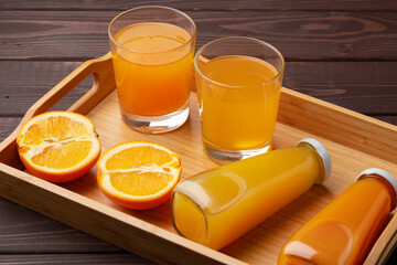Glass of fresh orange juice with fresh fruits on wooden table