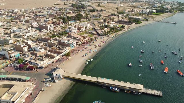 Paracas, Peru: Aerial drone footage of the Paracas town and harbor by the Pacific ocean in Peru, south of Lima. Shot with a downward and tilt up motion. 