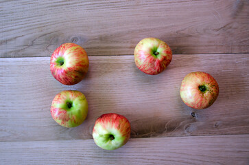 apples on a wooden surface, fresh apples scattered on a wooden surface