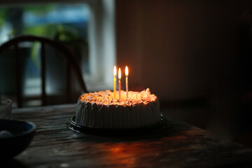 Birthday cake with three burning candles, dark style