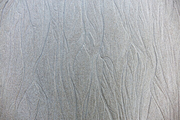 Sand background and texture. Wet beach sand texture after low tide. Sand with wave print. Ripple on the beach sand. 