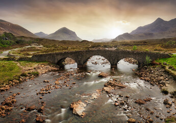 Sligachan old bridge on the Isle of Skye at beautiful sunset in Scotland. Nice landsape with river.