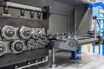 rollers at the machine for straightening the metal bar