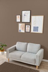 Interior of stylish living room with sofa near brown wall