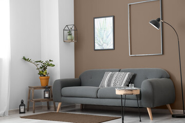 Interior of stylish living room with comfortable sofa near brown wall