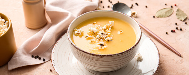 Bowl with tasty popcorn soup on grunge background