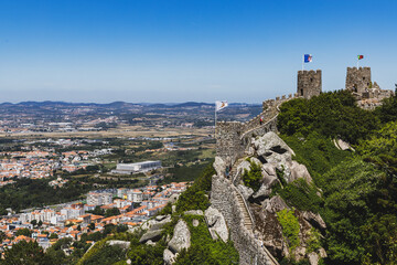 Fototapeta na wymiar Castle ruins with a flag overlook the town of Sintra in Portugal