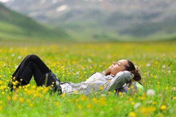 Hiker resting lying in a field in the mountain