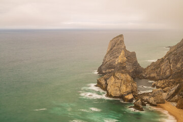 Tall, rugged haystack rocks jut out of the Atlantic ocean along the Portugal coast