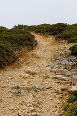Obraz premium A subtle trail marker shows the way up a hilly incline on a hiking trail in Portugal