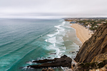 Obraz premium Rocky formations and fog amongst the waves on the coast of Portugal