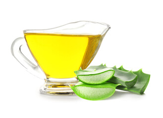 Fresh aloe vera leaves and gravy boat of honey on white background