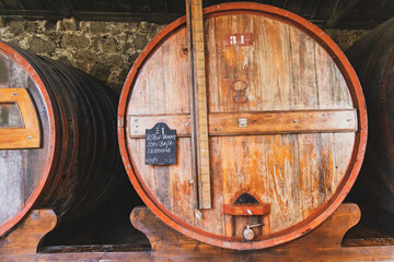 A large wooden cask with wine agin in a cellar
