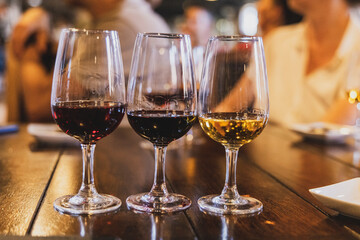 Three glasses of port wine in wine glasses at a wine tasting - obrazy, fototapety, plakaty