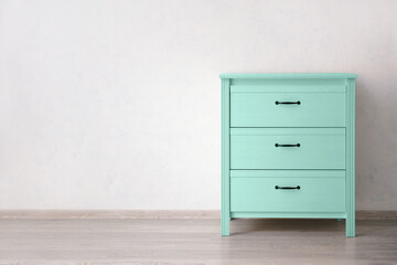 Modern mint chest of drawers near light wall in room