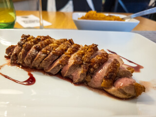 Roast duck with a muscat reduction on a white plate