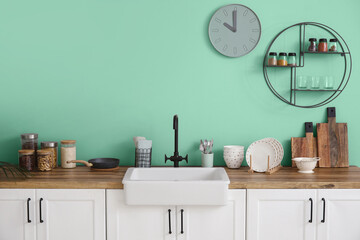Interior of modern kitchen with turquoise wall
