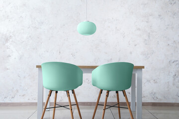 Dining table and chairs near light wall