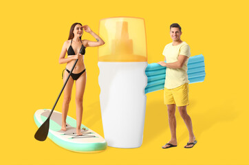 Happy young couple with board for sup surfing, inflatable mattress and bottle of sunscreen on yellow background