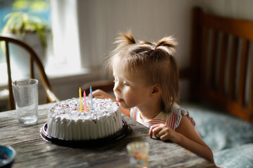 Child toddler tastes cake with his tongue