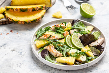 Salad of chicken breast with pineapple, avocado, green rocket salad, lime. Healthy juicy food. Food recipe background. Close up