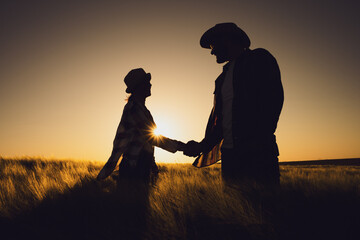 Fototapeta na wymiar Man and woman are working together in partnership. They are cultivating barley.