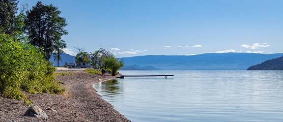 Wooden dock on a calm lake on beautiful summer morning, Okanagan Lake, Canada.