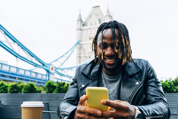 Smiling man text messaging on smart phone, London, England
