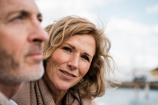 Thoughtful mature man by smiling woman