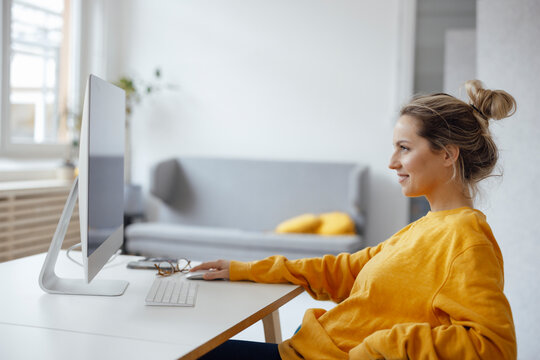 Businesswoman using desktop PC at home