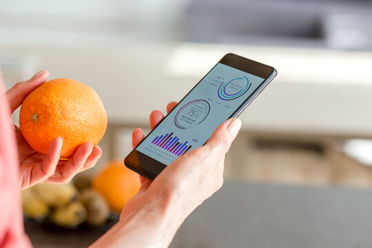 Woman holding smartphone with mobile app and orange