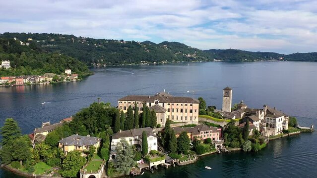 Flug &uuml;ber den Ortasee (Lago Orta) mit Blick &uuml;ber den See zur Insel San Giulio mit der mittelalterlichen historischen Basilika, Abtei und Kloster, Sommer, Sonne, blauer Himmel, Novara, Piemont, Italien