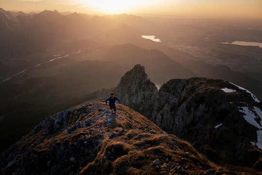 Hiker moving up on mountain peak at sunset