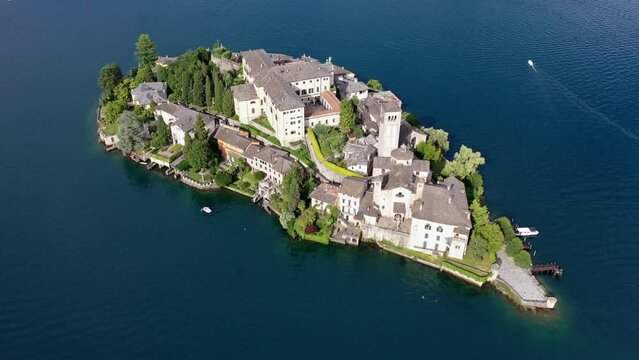 Flug &uuml;ber den Ortasee (Lago Orta) mit Blick &uuml;ber den See zur Insel San Giulio mit der mittelalterlichen historischen Basilika, Abtei und Kloster, Sommer, Sonne, blauer Himmel, Novara, Piemont, Italien