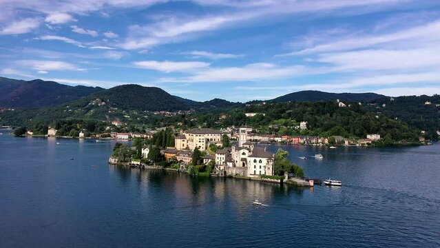 Flug &uuml;ber den Ortasee (Lago Orta) mit Blick &uuml;ber den See zur Insel San Giulio mit der mittelalterlichen historischen Basilika, Abtei und Kloster, Sommer, Sonne, blauer Himmel, Novara, Piemont, Italien