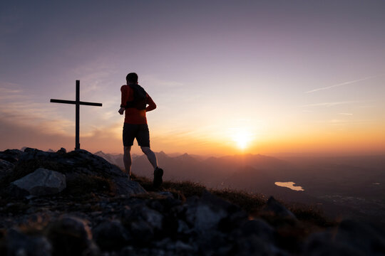 Silhouette hiker running on top of mountain